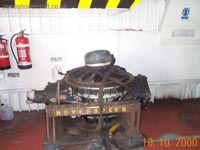 A gearbox being transported. Note its size compared to the two full-sized fire extinguishers. The input drive shaft to the gearbox would be connected to the left protrusion, the propeller shaft to the top (capped) and the lift fan to a protrusion on the bottom. An oil scavenge pump would be connected to the lowermost part of the flat plate on the right hand side, redistributing oil throughout the craft's systems.