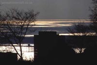 Looking across Dover harbour, with Burlington house silhouetted in the foreground in front of the then hollow Prince of Wales Pier, before the new hoverport was built